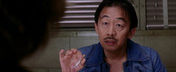 Movie still from “Starsky & Hutch” (2004), directed by Todd Phillips – A man holding a cigarette in his right hand; Close Up shot, Over the shoulder angle