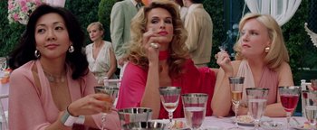 Movie still from “Starsky & Hutch” (2004), directed by Todd Phillips – A woman sitting at a table with a cigarette in her mouth; Medium shot, Low angle