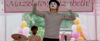 Movie still from “Starsky & Hutch” (2004), directed by Todd Phillips – Mime in striped shirt performing on stage in front of a crowd of onlookers; Medium shot, Low angle