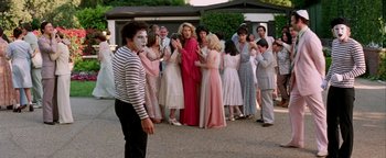 Movie still from “Starsky & Hutch” (2004), directed by Todd Phillips – A group of people standing in a circle with a man in a mime's face; Wide shot, Over the shoulder angle