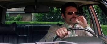 Movie still from “Starsky & Hutch” (2004), directed by Todd Phillips – A man driving a car wearing sunglasses and holding a steering wheel; Close Up shot, Low angle