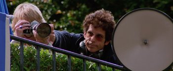 Movie still from “Starsky & Hutch” (2004), directed by Todd Phillips – A man with headphones and sunglasses is leaning on a railing; Medium shot, Low angle