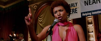 Movie still from “Starsky & Hutch” (2004), directed by Todd Phillips – A woman in a pink dress is holding a microphone; Close Up shot, Low angle