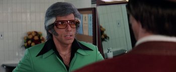 Movie still from “Starsky & Hutch” (2004), directed by Todd Phillips – A man in a green shirt and sunglasses; Close Up shot, Over the shoulder angle