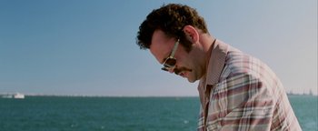Movie still from “Starsky & Hutch” (2004), directed by Todd Phillips – A person wearing glasses near a body of water; Close Up shot, Low angle