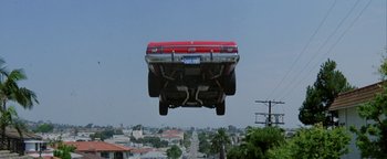 Movie still from “Starsky & Hutch” (2004), directed by Todd Phillips – A red car flying through the air over a street; Wide shot, Low angle