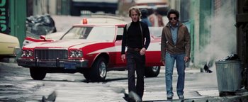 Movie still from “Starsky & Hutch” (2004), directed by Todd Phillips – Two men walking down the street in front of a red car; Wide shot, Low angle