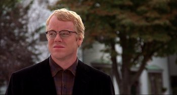 Movie still from “State and Main” (2000), directed by David Mamet – A man with blonde hair wearing glasses and a suit; Close Up shot, Over the shoulder angle