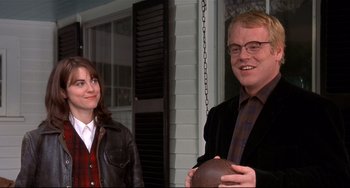 Movie still from “State and Main” (2000), directed by David Mamet – A man and a woman standing next to each other holding a ball; Medium shot, Over the shoulder angle