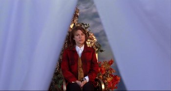 Movie still from “State and Main” (2000), directed by David Mamet – A woman sitting in a chair in front of a christmas tree; Medium shot, Low angle
