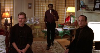 Movie still from “State and Main” (2000), directed by David Mamet – A group of people sitting in a living room; Medium shot, Over the shoulder angle