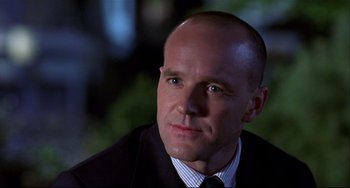Movie still from “State and Main” (2000), directed by David Mamet – A man in a suit and tie looking to his left; Close Up shot, Over the shoulder angle