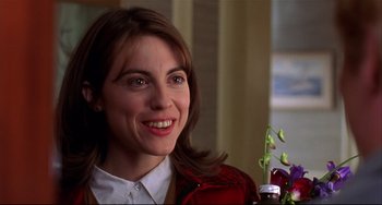 Movie still from “State and Main” (2000), directed by David Mamet – A person with a flower in a vase; Close Up shot, Over the shoulder angle