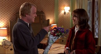 Movie still from “State and Main” (2000), directed by David Mamet – A man giving a woman a bouquet of flowers; Medium shot, Over the shoulder angle