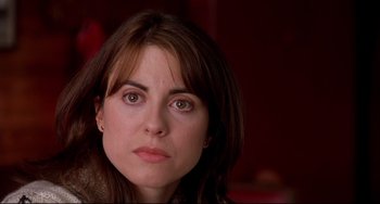 Movie still from “State and Main” (2000), directed by David Mamet – A woman's face in a dark room; Close Up shot, Over the shoulder angle