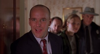 Movie still from “State and Main” (2000), directed by David Mamet – A man in a suit and a red neck tie; Close Up shot, Over the shoulder angle