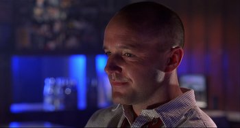 Movie still from “State and Main” (2000), directed by David Mamet – A man with a shaved head wearing a neck tie; Close Up shot, Low angle