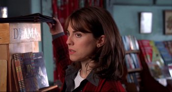Movie still from “State and Main” (2000), directed by David Mamet – A woman with long brown hair holding a pair of shoes; Close Up shot, Low angle