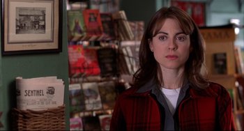 Movie still from “State and Main” (2000), directed by David Mamet – A woman standing in front of a book shelf; Close Up shot, Over the shoulder angle