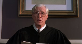 Movie still from “State and Main” (2000), directed by David Mamet – An older man wearing a black robe and glasses; Close Up shot, Low angle