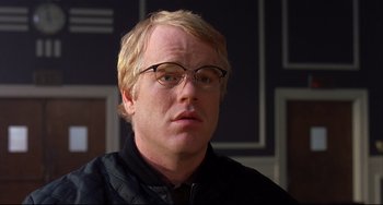 Movie still from “State and Main” (2000), directed by David Mamet – A person wearing glasses and a jacket; Close Up shot, Over the shoulder angle