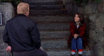 Movie still from “State and Main” (2000), directed by David Mamet – A man and a woman sitting on the steps of a building; Medium shot, Over the shoulder angle