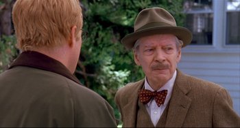 Movie still from “State and Main” (2000), directed by David Mamet – An older man wearing a hat and a bow tie talking to a younger man; Close Up shot, Over the shoulder angle