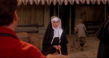 Movie still from “State and Main” (2000), directed by David Mamet – A woman dressed as a nun with a wicker basket; Medium shot, Over the shoulder angle