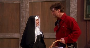 Movie still from “State and Main” (2000), directed by David Mamet – A man and a woman dressed as a nun; Medium shot, Over the shoulder angle