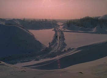 Movie still from “A Railway Station for Two” (1983), directed by Eldar Ryazanov – A couple of people riding skis on top of a snow covered slope; Extreme Wide shot, High angle