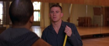 Movie still from “Step Up” (2006), directed by Anne Fletcher – A man holding a yellow pole in front of a mirror; Close Up shot, Over the shoulder angle