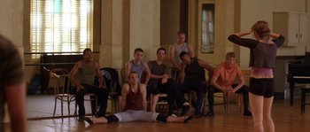 Movie still from “Step Up” (2006), directed by Anne Fletcher – A group of men sitting on top of a wooden floor; Wide shot, High angle