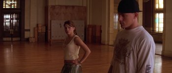 Movie still from “Step Up” (2006), directed by Anne Fletcher – A woman standing in a room with a man standing next to her; Medium shot, Over the shoulder angle