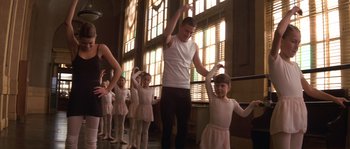 Movie still from “Step Up” (2006), directed by Anne Fletcher – A group of young girls and a man in a white shirt and black pants; Wide shot, Low angle