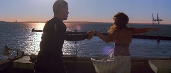 Movie still from “Step Up” (2006), directed by Anne Fletcher – A man and a woman holding hands near the ocean; Medium shot, Low angle