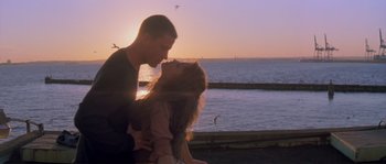 Movie still from “Step Up” (2006), directed by Anne Fletcher – A man and a woman kissing in front of a body of water; Medium shot, Low angle