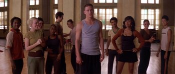 Movie still from “Step Up” (2006), directed by Anne Fletcher – A group of young men standing in a room; Medium shot, Low angle