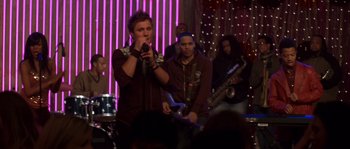 Movie still from “Step Up” (2006), directed by Anne Fletcher – A group of people that are standing in a room together; Medium shot, Over the shoulder angle