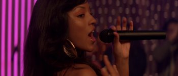 Movie still from “Step Up” (2006), directed by Anne Fletcher – A woman singing into a microphone in a dark room; Close Up shot, Over the shoulder angle