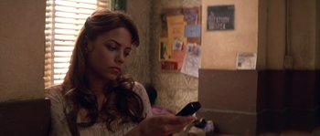 Movie still from “Step Up” (2006), directed by Anne Fletcher – A woman sitting at a table looking at her phone; Close Up shot, High angle