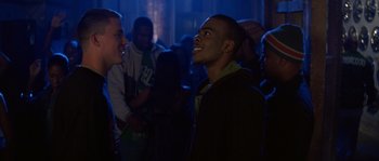 Movie still from “Step Up” (2006), directed by Anne Fletcher – A group of young men standing in a dark room; Medium shot, Over the shoulder angle