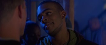 Movie still from “Step Up” (2006), directed by Anne Fletcher – A young man smiling for the camera in a dark room; Close Up shot, Over the shoulder angle