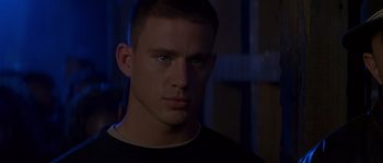 Movie still from “Step Up” (2006), directed by Anne Fletcher – A person wearing a black t - shirt; Close Up shot, Over the shoulder angle