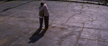 Movie still from “Step Up” (2006), directed by Anne Fletcher – A man and a woman hugging in a parking lot; Extreme Wide shot, High angle