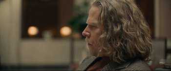 Movie still from “Stockholm” (2018), directed by Robert Budreau – A person with long hair; Close Up shot, Over the shoulder angle
