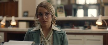 Movie still from “Stockholm” (2018), directed by Robert Budreau – A woman wearing glasses and a green jacket; Close Up shot, Over the shoulder angle