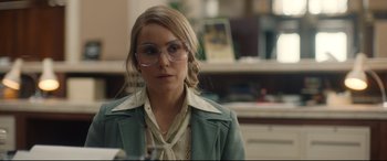 Movie still from “Stockholm” (2018), directed by Robert Budreau – A woman in a green jacket and glasses; Close Up shot, Over the shoulder angle