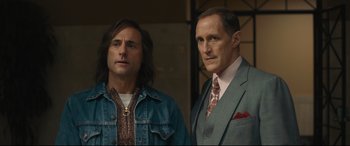 Movie still from “Stockholm” (2018), directed by Robert Budreau – Two men standing next to each other in front of a building; Medium shot, Low angle