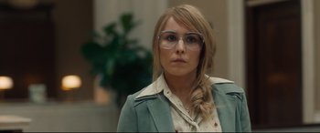 Movie still from “Stockholm” (2018), directed by Robert Budreau – A woman wearing glasses and a green jacket; Close Up shot, Over the shoulder angle