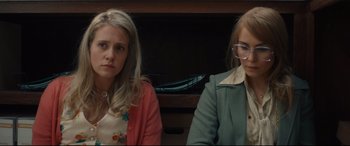 Movie still from “Stockholm” (2018), directed by Robert Budreau – Two women sitting next to each other in front of a tv; Close Up shot, Low angle